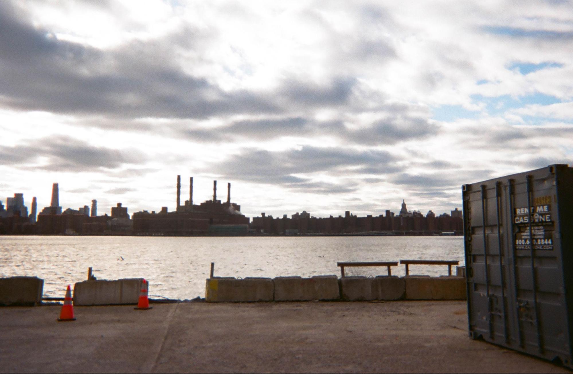 Brooklyn waterfront looking across to the Manhattan skyline, industrial smokestacks in silhouette