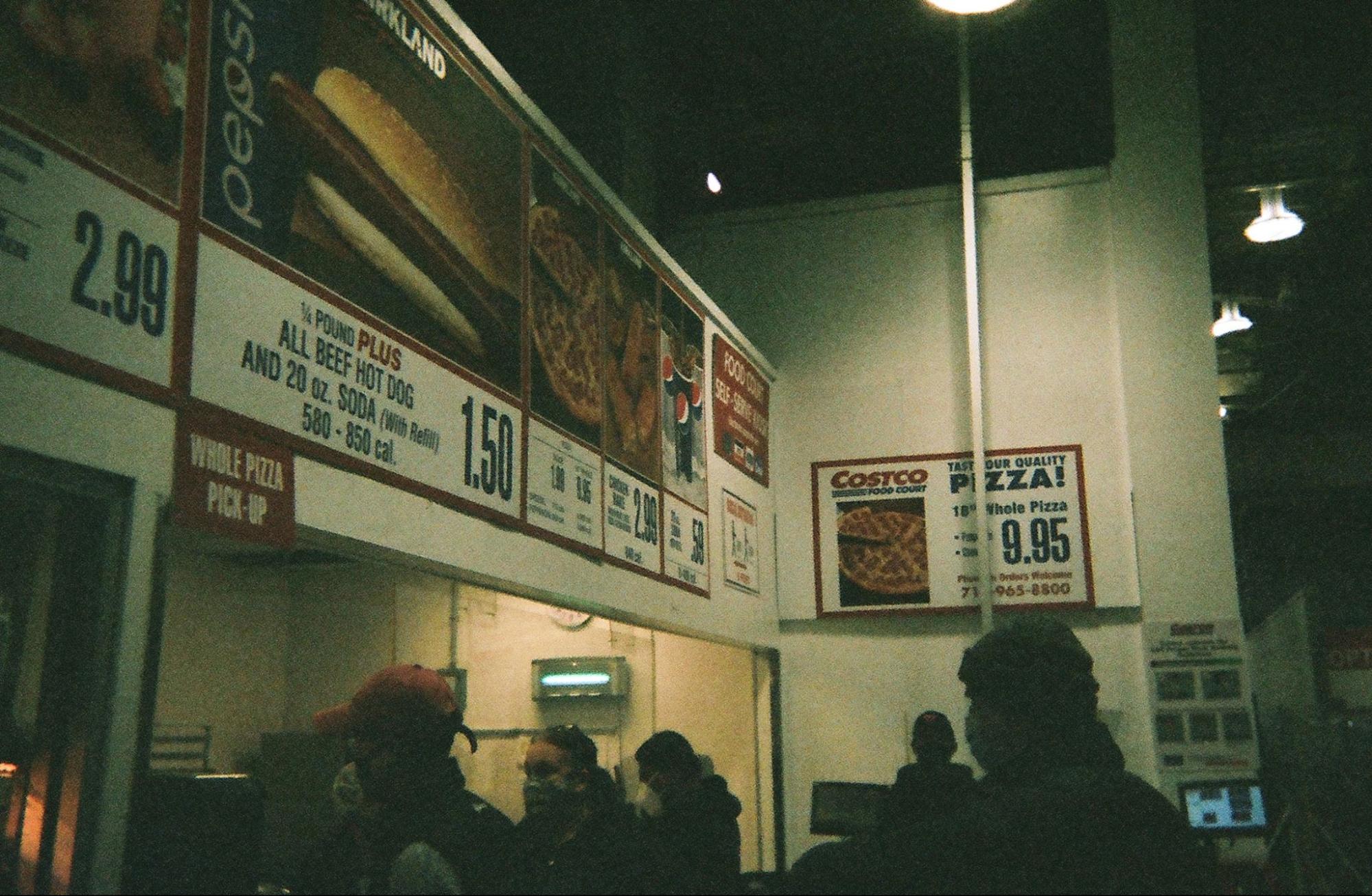 Costco food court, menu boards overhead, crowd below